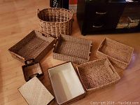 Top view of 8 assorted baskets showing variety of sizes, shapes, and woven textures including lined and lidded baskets.