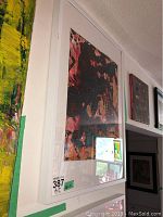 Framed abstract artwork by Alex Hare viewed at an angle showing white frame and part of adjacent artworks.