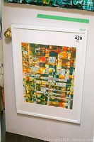 Full view of framed abstract painting leaning against a white door showing overall condition