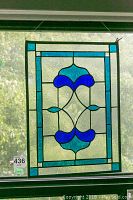 Full front view of the stained glass panel hanging in a window