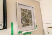 Framed original artwork by Alex Hare with white frame and abstract brown and beige tones measuring approximately 15x12 inches.
