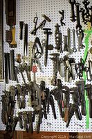 Pegboard display showing lower section with assorted pipe wrenches, pliers and specialized wrenches
