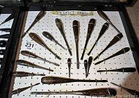 Fan-arranged wooden-handle screwdrivers on pegboard