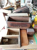 Overview of 7 wooden cheese boxes in varying sizes and wood tones, some with sliding lids and dovetail joints, showing aged wear and some chips.