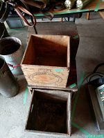 Photo showing Canadian Butter Ontario wooden crate with registration number and date markings, atop another crate with visible wood wear.