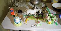 Overall view of the lot showing the Beswick horse and foal figurines, bunny music box, small decorative yellow bird, and detached floral piece parts arranged on a table.