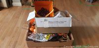 Box of assorted Halloween decorations including fabric pieces and fall garland