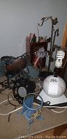 Wide view of candles, candle holders, and a baseball lamp base on a carpeted floor.
