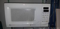 External photo of white LG microwave, showing model and keypad