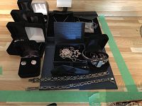 Overhead shot of assorted sterling silver jewelry including multiple stamped 925 chains, bracelets and earrings in boxes