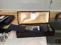Vintage costume jewelry including bug brooches and pendants displayed in open jewelry box on a surface.