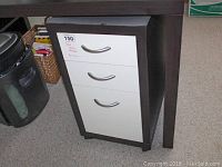 Front view of rolling desk storage unit showing three white drawer fronts with metal handles and dark wood frame.