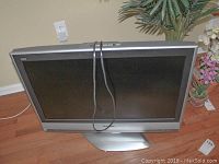 Front view of Panasonic TV model TC32LX60 on swivel base with power cord visible.
