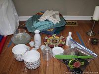 Six white ceramic bowls with multi-color dots, eight matching small plates, plastic honey holder, kitchen utensils in green handles, white and cream linen napkins, assorted placemats, Pier1 decorative plate