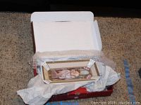 Rectangular Goebel decorative dish inside open original box with bubble wrap cushioning on carpeted floor.
