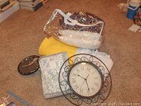 Wide shot showing bedding items, pillows, and wall clocks on carpeted floor.