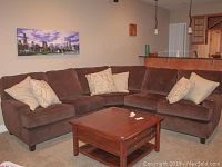 Front view of brown sectional sofa with throw pillows on carpeted floor