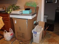 Photo of corrugated plastic storage boxes stacked with small boxes on top inside a room.