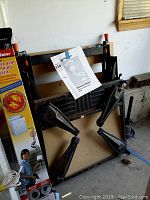 Collapsed Black and Decker Workmate 400 work table leaning against a wall, showing rust and wear on metal parts.