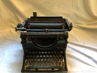 Front angled view of black Underwood Number Five typewriter showing round keys and carriage mechanism.