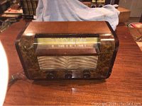 Front view of vintage RCA Victor radio showing wood cabinet, fabric speaker grill, and tuning dial.
