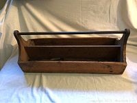 Wooden antique carpenter's toolbox with metal handle, front view showing compartments