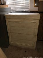 Front and side views of a wooden antique dresser painted light color, showing the paneled drawer fronts and overall shape.