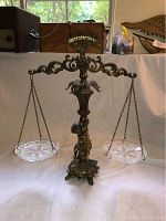 Full view of antique balance scale with glass trays on either side.