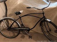 Side view of the full bicycle showing black frame with chrome fenders and original seat and decals.