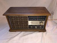 Full view of the RCA Victor mid century AM FM radio in wooden case showing fabric speaker cover and tuning panel