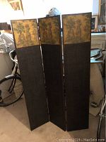 View of full three-panel folding wooden room divider with silkscreen scenes at top and woven lower parts.