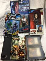 Photo showing entire lot including Dexter bobblehead in box, Avengers Skrull Soldier action figure, Terminator 2 Future War Hot Blast action figure, and World of Warcraft card packs and rulebook.