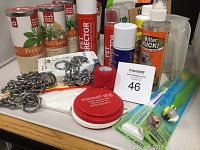 Overview of lot showing wet dog food cans, metal choke chains, sprays, clicker, and toy.