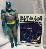 Batman action figure standing next to Batman Digital Justice comic book, cape worn and torn