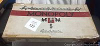 Overview of Monopoly game box with visible wear, tape repairs and classic Monopoly graphics.