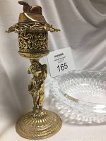 Photo showing vintage gold-tone table lighter with cherub stand and cut glass ashtray side by side.