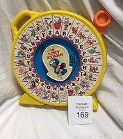 Front view of the yellow and blue vintage Mickey Mouse ABCs educational toy showing alphabet wheel and Mickey Mouse center.