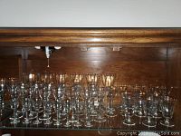 Wide view of 47-piece vintage delicate ribbed stemware set showing multiple types including goblets and liqueur glasses.