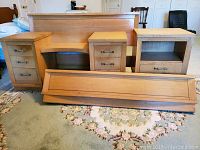 Full view of the dresser, makeup console/dresser, end table, headboard and footboard laid out on a patterned area rug
