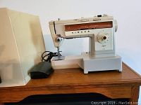 Front view of the Singer Stylist 543 portable sewing machine with foot pedal and power cord.