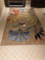 Full view of the wool wool pile area rug showing the floral pattern and overall condition on a carpeted floor.