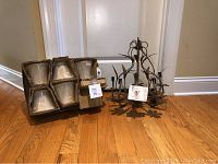 Chandelier frame with leafy metal vine design alongside boxed shades.