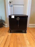Front view of the filing chest showing the full rectangular shape with short legs and black faux leather with crocodile texture.