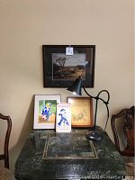 Full lot displayed: four wall hangings and a black desk lamp on marble table with two chairs