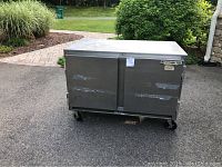 Front view of two-door stainless steel commercial Beverage Air refrigerator on wheels with visible scratches and marks.