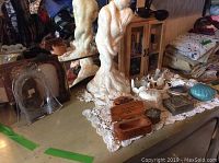 View of trinket boxes, ceramic lovers statue, tea light holders on table with lace covering