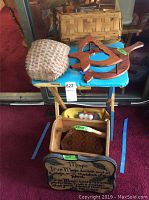Photo of Longaberger basket on wooden folding table with various wood decor pieces in front and underneath the blue table