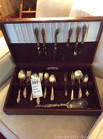 Full open box of silverplate flatware showing variety of utensils in fitted compartments.