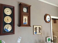 Wall mounted clocks and weather instrument set with framed wall art below