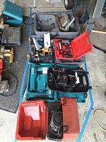 Overview photo showing power tools and cases on concrete floor